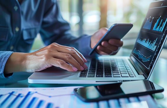 A person engaged in online payment using a laptop and a cell phone simultaneously