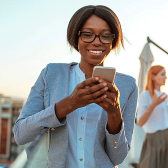 A woman with glasses checks her phone