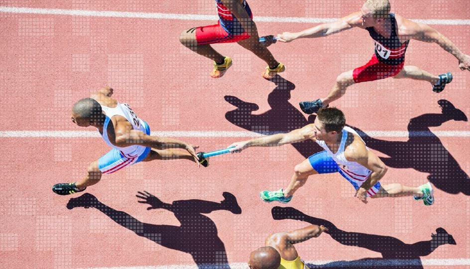 Athletes sprinting on a track, with one runner handing off a baton to another in a relay event.